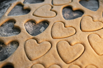 Fototapeta na wymiar cooking heart shaped cookies in dough closeup