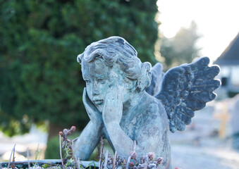 schöner alter Engel stützt den Kopf in den Händen  auf einem Friedhof in Ratingen