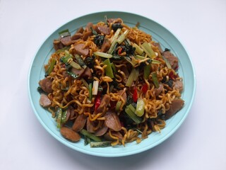 fried noodles with mixed mustard greens on a plate top view against a white background. healthy food background concept, food recipe, restaurant, breakfast, lunch, dinner, traditional food, lifestyle