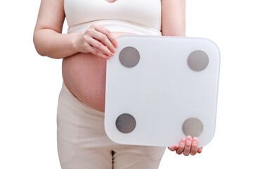 A pregnant woman holds a weighing scale in her hands, isolated on a white background