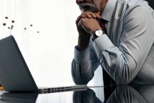 Senior man checking working on laptop in kitchen at home