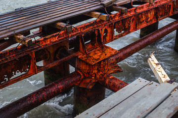 Old red rusty pier and atmospheric stormy sea with a rich blue color of water and clouds. Minimalistic storm landscape