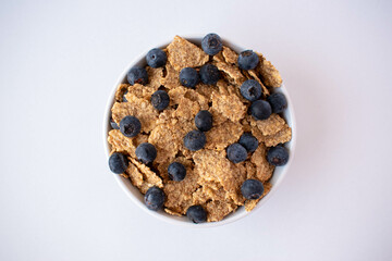Delicious fresh breakfast, granola and fruit served in a bowl. White background. Close-up. Top view.