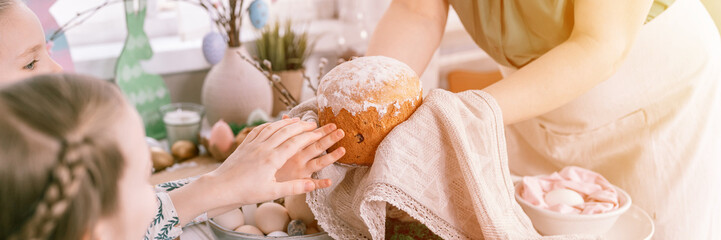 happy easter holiday time in spring season. family kid girls children sisters and woman holds baked pastry cake or traditional bread in her hands. handmade food. festive home decor. banner. flare