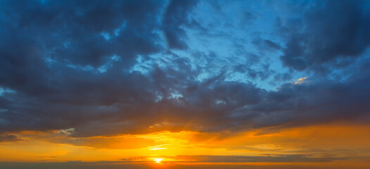 Naklejka na ściany i meble dense cloudy sky at the dramatic sunset, beautiful natural evening sky background