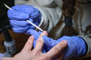 Close-up manicure master works in gloves in the salon.