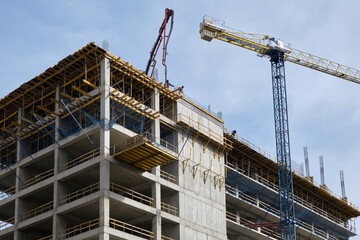Workers pour concrete at the construction site of a new residential building