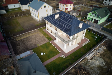 Aerial drone view of autonomous house with photovoltaic solar panels on rooftop. Home with solar...