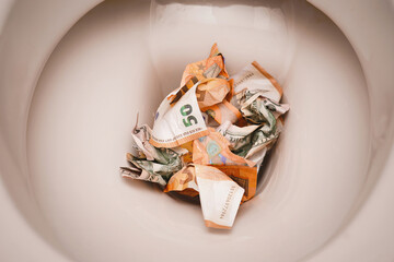 Banknotes dollars and euros are thrown into the toilet.