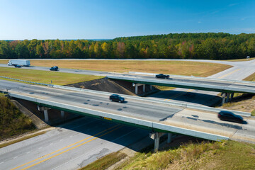 Elevated view of freeway exit junction over road lanes with fast moving traffic cars and trucks. Interstate transportation infrastructure in USA