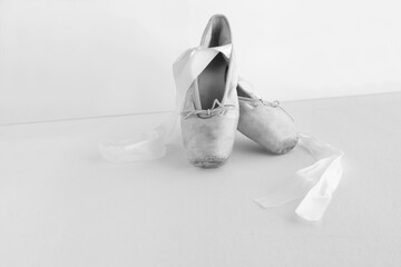 pair of neatly arranged ballet shoes. white background with copyspace, pointe shoes black and white