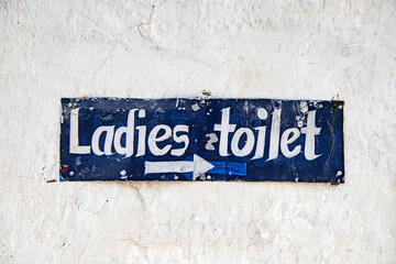 Handpainted sign ''ladies toilet'' in white and blue.