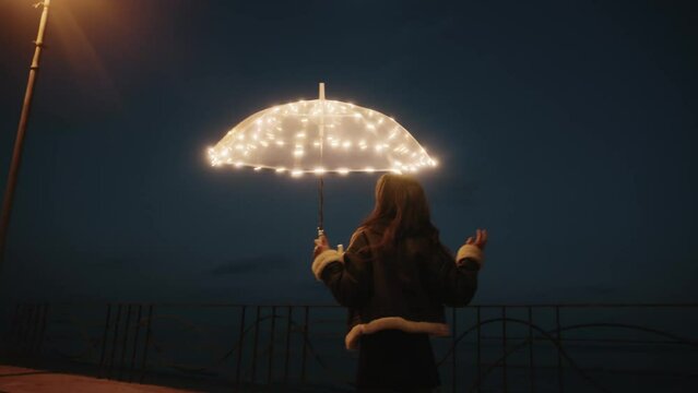 Happy girl with transparent umbrella in the night 