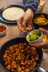 Unrecognizable person serving guacamole with spoon. Healthy food