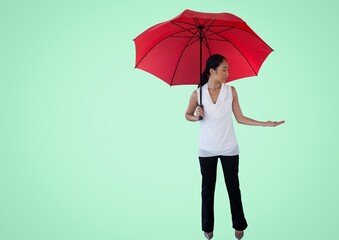 Asian woman with umbrella holding an invisible object against copy space on green background