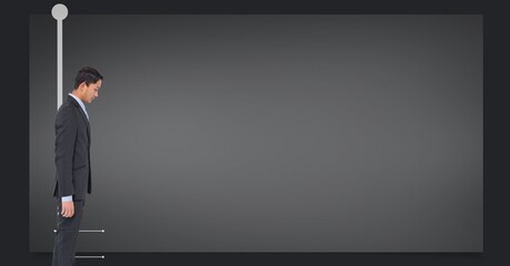 Obraz premium Asian businessman standing against copy space on grey background