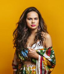 Girls with Hispanic appearance in bright clothes on a yellow background