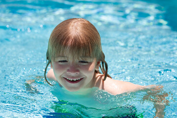 Happy child playing in swimming pool. Summer kids vacation.