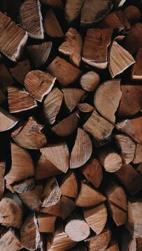 Chopped firewood is stacked in a big pile Slow motion Vertical video