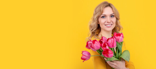 glad young woman with spring tulip flowers on yellow background. Woman isolated face portrait, banner with mock up copy space.