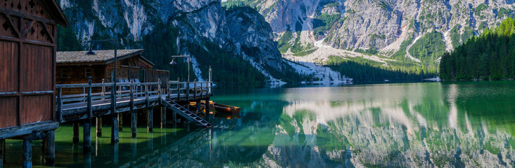 Obraz premium Lake surrounded by the mountains of the Italian alps. Fabulous views, magnificent mountains and lake. Free space for inscription text poster on backdrop nature Lake Braies emerald clear water.