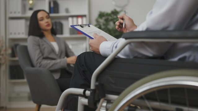 Male psychologist with disability having therapy session with woman patient