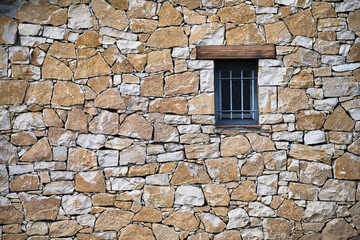 Fototapeta na wymiar stone wall with window tough mosaic dirty built concrete rural urban weathered historical mediterranean backgrounds growth real stack tradition vibrant cracked drywall florence medieval pebble stacked