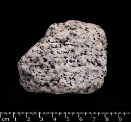 Granodiorite stone, igneous rock, isolated on black background (diameter is about 5 cm)