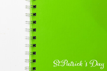 Green notebook with text St Patricks Day on white background. St Patricks Day celebration concept