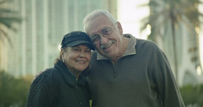 Attractive Older Couple At Park Looking At Camera And Smiling