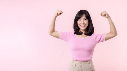 Portrait young asian woman proud and confident showing strong muscle strength arms flexed posing,...