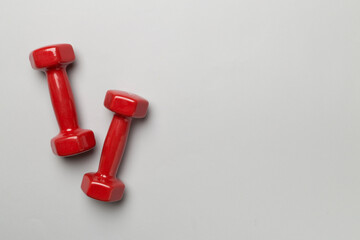 Red dumbbells on color background, top view