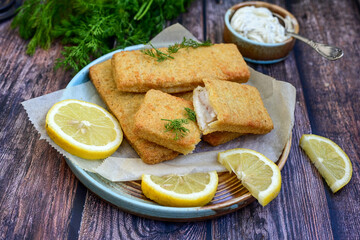   Allasca Pollock Fish  Bites in a crispy Tempura  Batter.Fish and chips .Close up of   crispy breaded  deep fried fish fingers with breadcrumbs s erved with remoulade sauce and  lemon