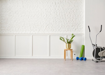 Decorative modern new style sport room in the house, mat, dumbbell, bike and white background wall.