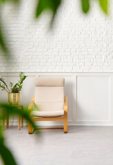 Rocker chair in the white room, brick and classic wall background, chamber, green plant leaf close up blur, working table.