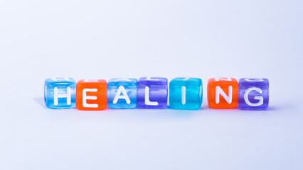colorful blocks form the word "healing". concept of healing