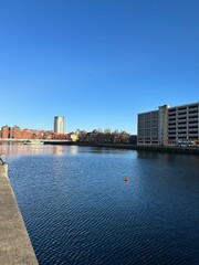 Obraz premium Modern buildings and landmarks next to the water with a blue sky background. Salford Quays England. 