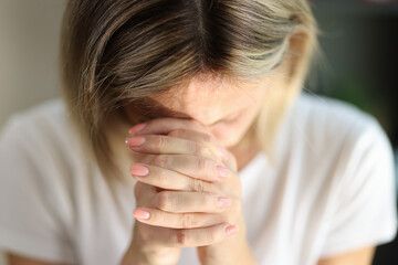 Fototapeta premium Praying woman folded hands, tilting head and prays