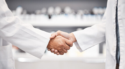 Doctor, handshake and partnership in healthcare, medicine or trust for collaboration, unity or support at lab. Team of medical experts shaking hands in teamwork for agreement or success at pharmacy