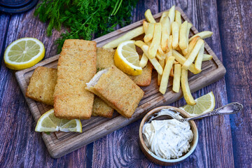   Allasca Pollock Fish  Bites in a crispy Tempura  Batter.Fish and chips .Close up of   crispy breaded  deep fried fish fingers with breadcrumbs s erved with remoulade sauce and  lemon