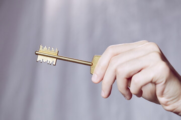  Close up of human hand holding golden key