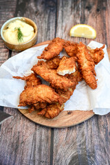 
 Crispy  deep fried   Chicken strips and wedges potato. Breaded  with cornflakes chicken  Breast fillets  with chilly peppers and fresh   basil on wooden rustic background