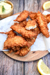 
 Crispy  deep fried   Chicken strips and wedges potato. Breaded  with cornflakes chicken  Breast fillets  with chilly peppers and fresh   basil on wooden rustic background