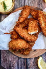 
 Crispy  deep fried   Chicken strips and wedges potato. Breaded  with cornflakes chicken  Breast fillets  with chilly peppers and fresh   basil on wooden rustic background