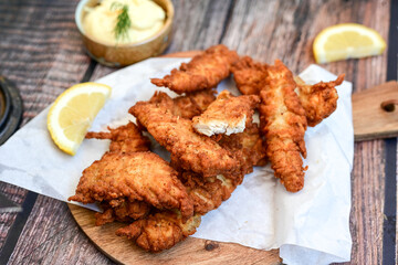 
 Crispy  deep fried   Chicken strips and wedges potato. Breaded  with cornflakes chicken  Breast fillets  with chilly peppers and fresh   basil on wooden rustic background