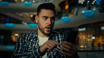 Surprised happy male buyer client businessman winner use phone click on mobile screen win shopping discounts jackpot arabian man make online order celebrate success business profit excited reaction