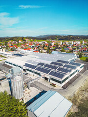 Vertical photo of a large warehouse with solar panels on the roof top © VisualProduction