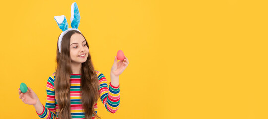 happy easter child girl in rabbit bunny ears showing painted eggs for holiday. Easter child horizontal poster. Web banner header of bunny kid, copy space.