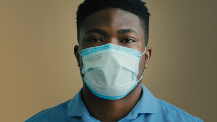Adult male businessman sick ill african man patient office worker employee in medical mask respirator protect health from grippe stop coronavirus infection flu symptoms close up masked face portrait