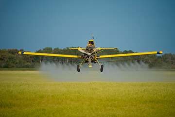 Crop dusting over a canola field
